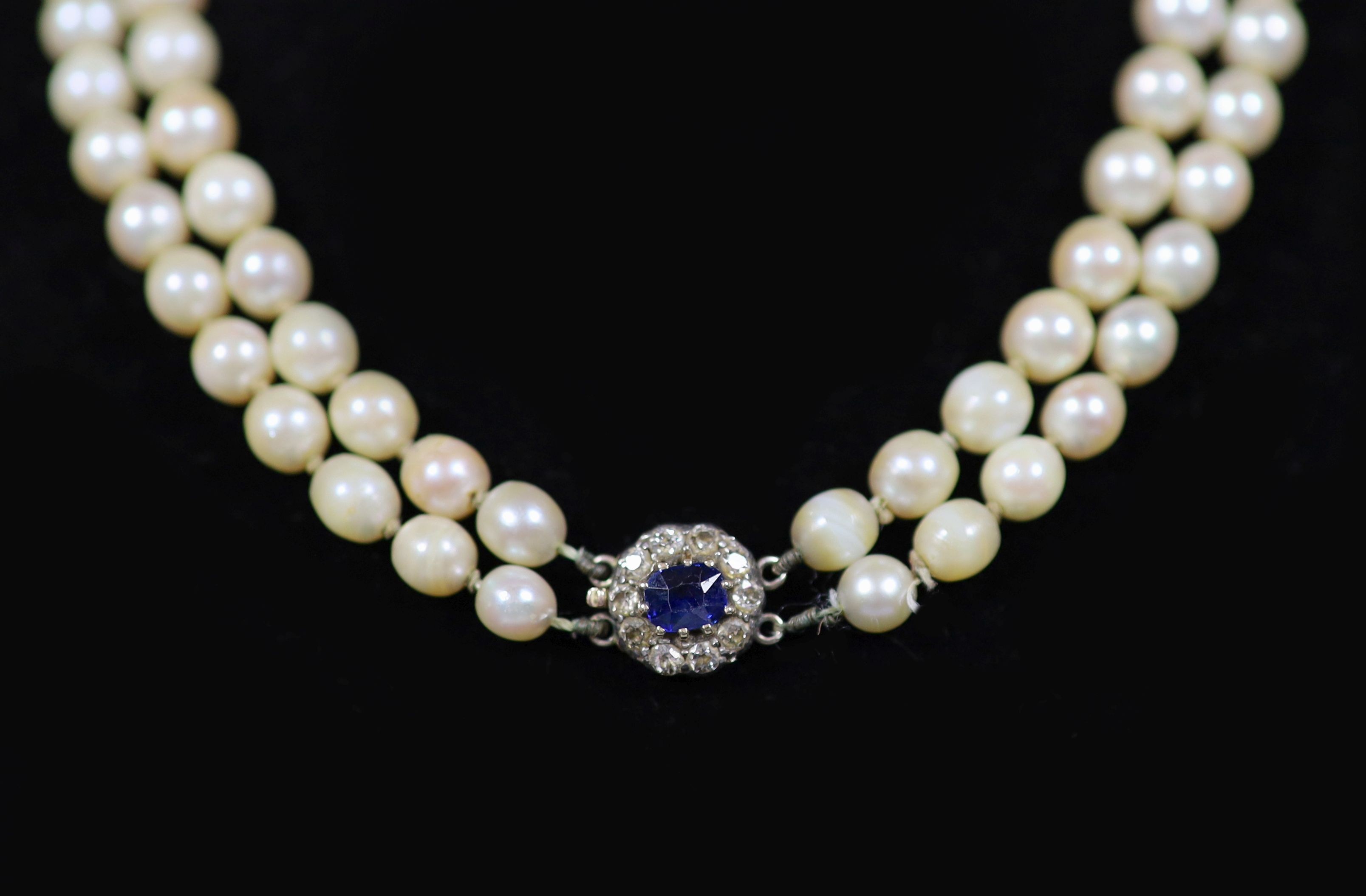 An early 20th century double strand graduated cultured pearl choker necklace, with sapphire and diamond cluster set gold clasp